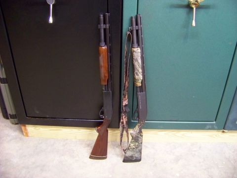 1995 Mercury Grand Marquis - Two shotguns are shown leaning against large gun safes, one with a wooden stock and the other with a camouflage finish.