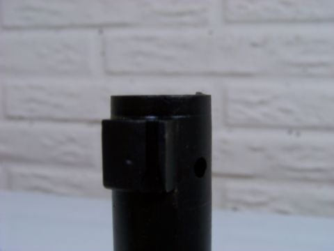1995 Mercury Grand Marquis - A close-up view of a black metal component against a white brick background.