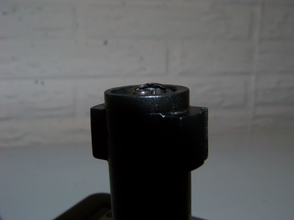 Close-up of a black metal part with a circular opening at the top