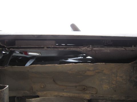 1996 Ford Bronco - The undercarriage of a vehicle shows significant wear and tear, with visible rust and dirt accumulation.