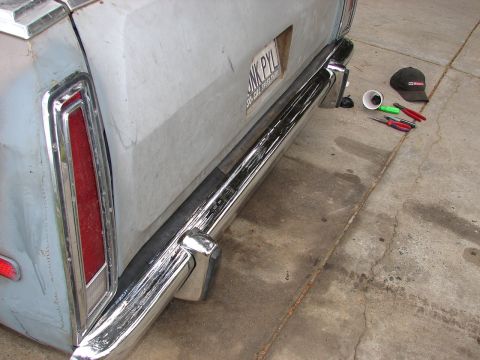 1973 Ford Ranchero - The rear of a 1973 Ford Ranchero shows a chrome bumper and a license plate with tools nearby.