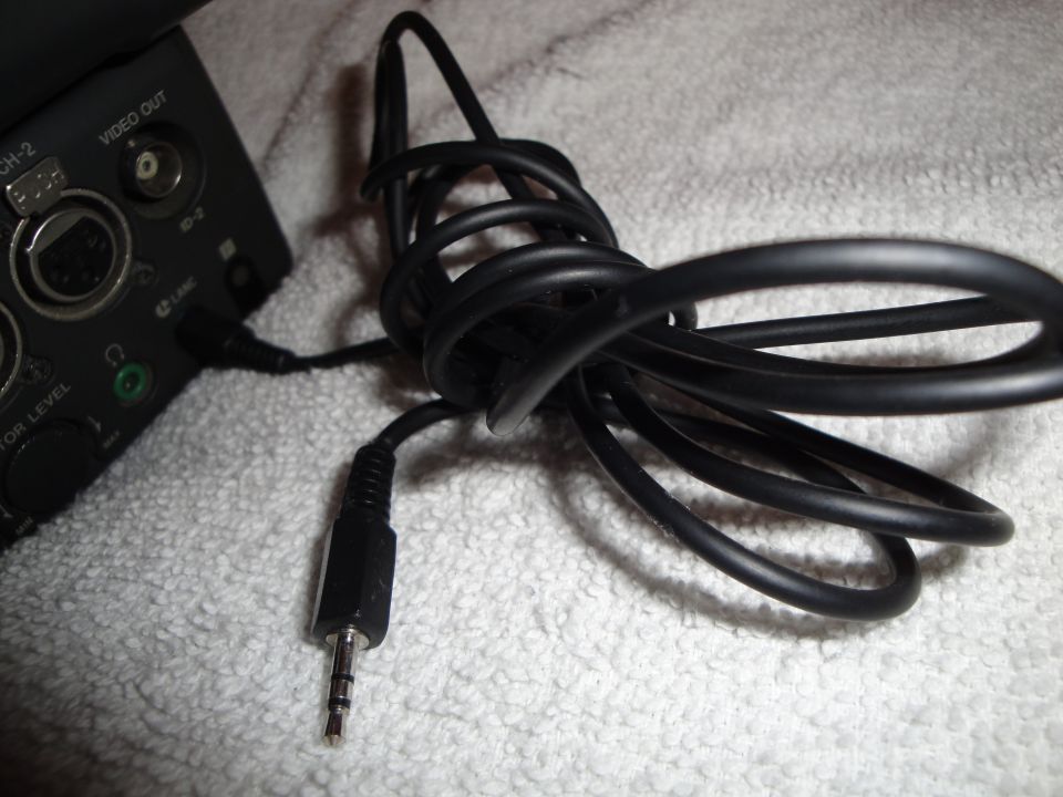 Black audio cable plugged into a video device with 'VIDEO OUT' and 'CH-2' labels