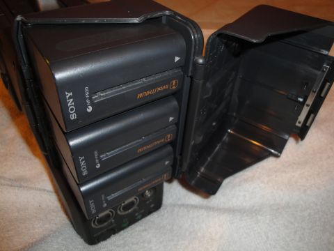 1993 Ford Taurus - A black charger holds three Sony NP-F930 InfoLITHIUM batteries, with the lid open to reveal the interior.