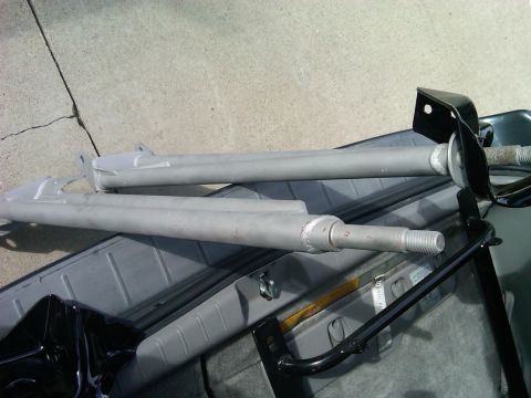 1986 Ford Bronco - Two gray radius arms are shown, each with a threaded end and black mounting brackets attached.