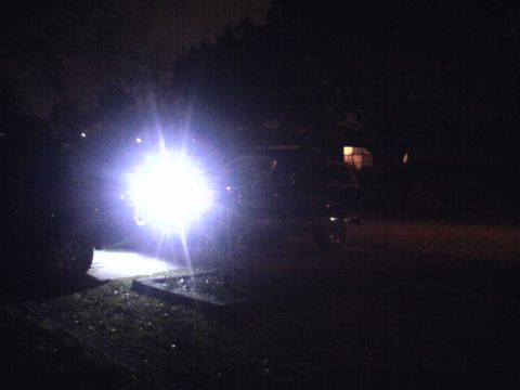 1994 Ford Bronco - An SUV's headlights are intensely bright, illuminating the dark surroundings.
