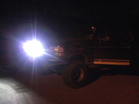 1994 Ford Bronco - Ford Bronco's bright headlights illuminate the night scene.