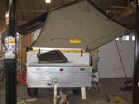 1996 Ford Bronco - A trailer equipped with a pop-up tent is shown in a garage setting, a diamond plate toolbox and a green cover.