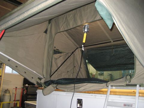 1996 Ford Bronco - The inside of a pop-up camper tent is shown, with a light and a ladder visible.