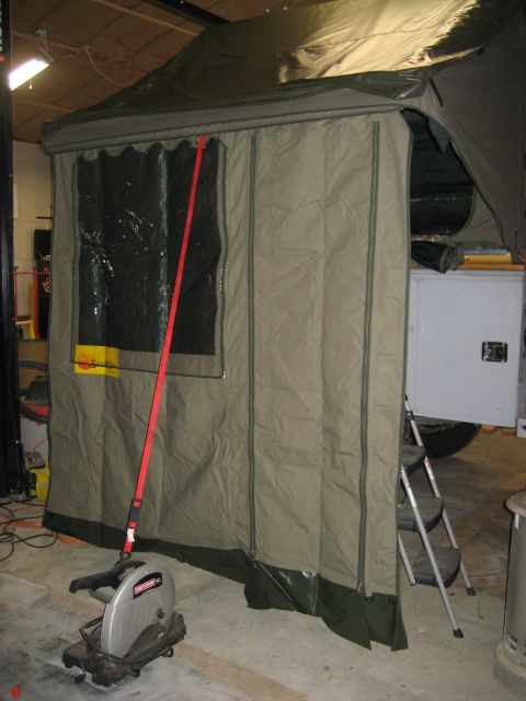 1996 Ford Bronco - Tent trailer setup in a garage, showing a ladder and a chop saw. The trailer has a window and green trim.