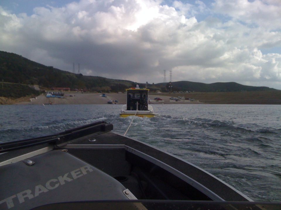 View from a Tracker boat towing a yellow and white boat on a lake