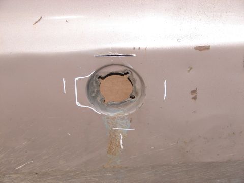 1973 Ford Ranchero - A close-up view of a circular opening on a vehicle's exterior panel, marked with chalk.