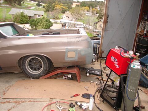 1973 Ford Ranchero - 1973 Ford Ranchero side view, being worked on in a garage with welding equipment.