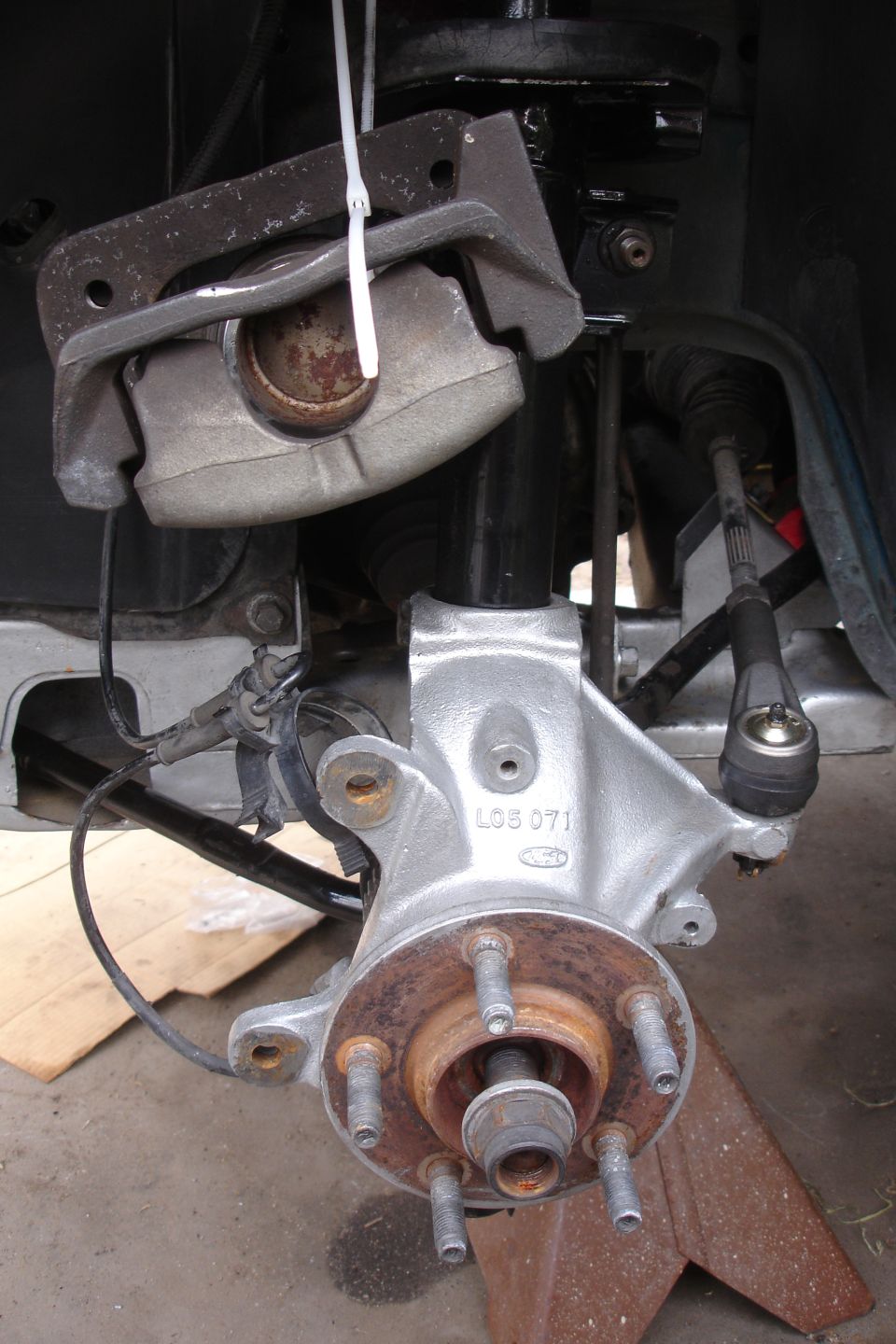 close-up of car's front brake caliper and hub assembly, part of suspension system