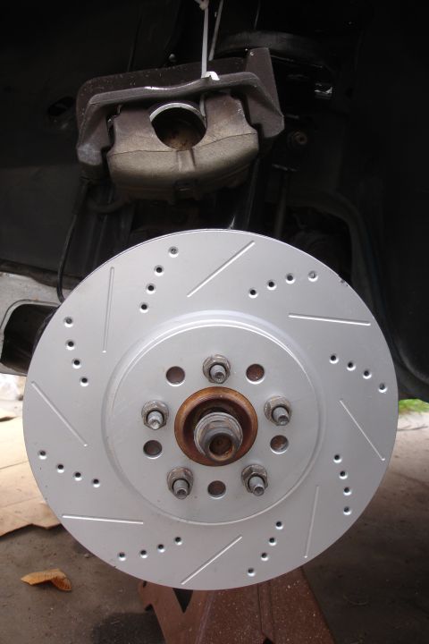 1995 Ford Taurus - Close-up of a drilled and slotted brake rotor and caliper, likely a performance upgrade part.