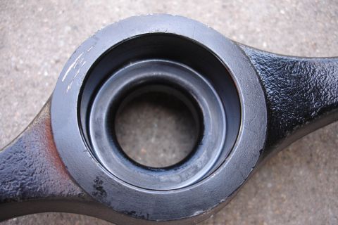 1995 Ford Taurus - Close-up of a dark-colored automotive suspension part with a central bore and visible wear marks.