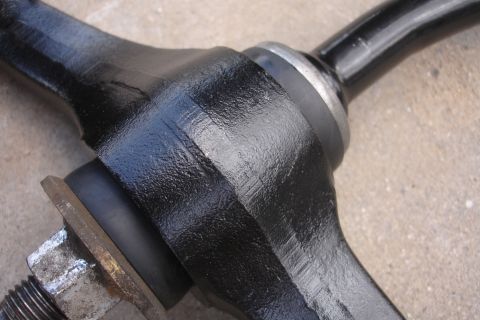 1995 Ford Taurus - Close-up of a black painted automotive suspension part, likely a control arm or similar component.