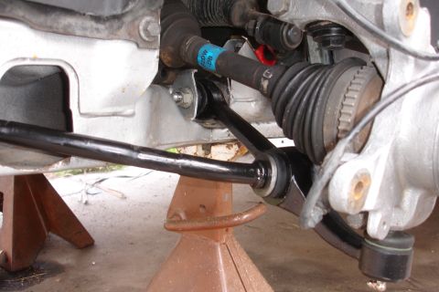 1995 Ford Taurus - Close-up view of front suspension parts, including a control arm and CV axle, with a blue label visible on a hose.