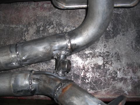 1991 Ford Bronco - Close-up view of a custom-fabricated exhaust y-pipe, showing the welding and a bracket.