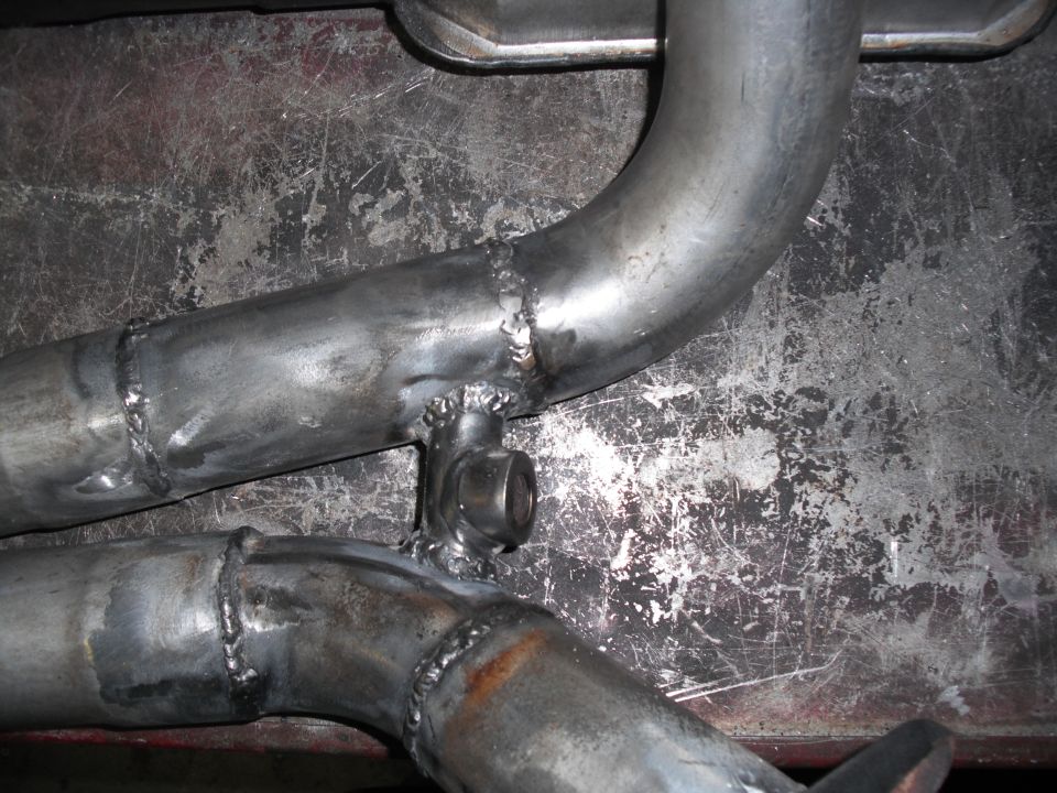 Custom exhaust y-pipe with visible welds and a mounting bracket