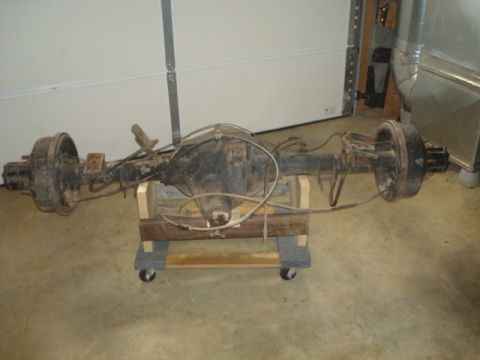 1995 Ford Bronco - Rear axle assembly, likely from a truck or SUV, is shown mounted on a wheeled wooden stand.