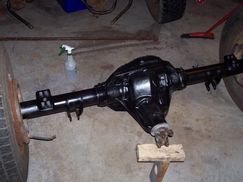 1994 Ford Bronco - A black rear axle assembly is shown, with one tire attached and the other end supported by blocks.