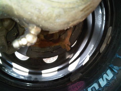 2008 Jeep Wrangler - A close-up view of a vehicle's wheel and brake components, showing signs of rust and wear.