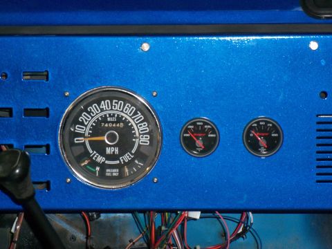 1978 Jeep CJ5 - Close-up of a blue dashboard a speedometer and two additional gauges, with visible wiring below.