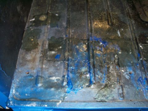 1978 Jeep CJ5 - The interior floor of a vehicle shows signs of wear and tear, with blue paint and rust visible.