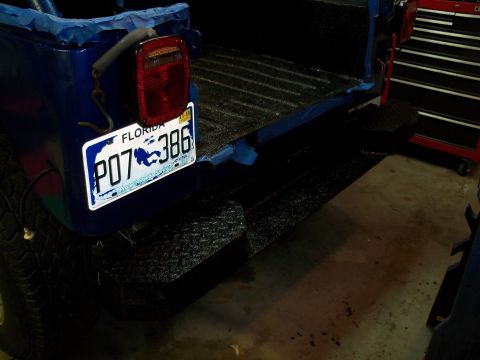 1978 Jeep CJ5 - Rear view of a blue 1978 Jeep CJ5 with a textured black bumper and tailgate.