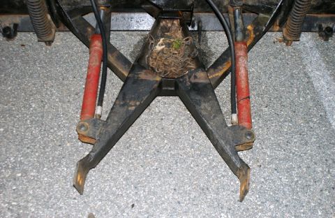 1979 Ford Bronco - A close-up view of a snow plow attachment, showing its mechanical components and a bird's nest.