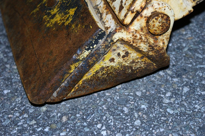 Rusted bucket with yellow paint remnants