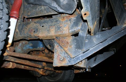 1979 Ford Bronco - Close-up view of heavily rusted vehicle frame and suspension components.