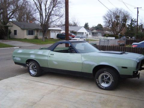 1973 Ford Ranchero - This 1973 Ford Ranchero shows primer spots on its light green body and black vinyl roof, viewed from the front three-quarter angle.
