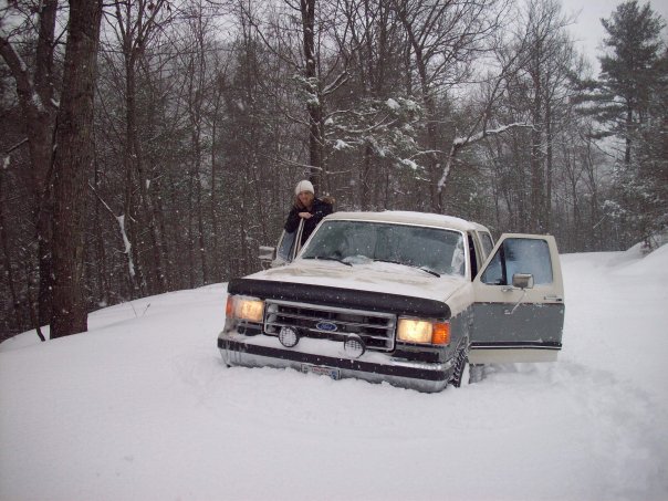 Two-tone Ford F-Series truck stuck in snow, front view