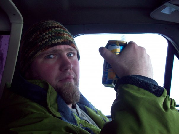 Man holding a can inside a vehicle, interior view