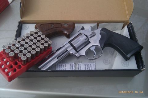2000 Mercury Grand Marquis - A revolver, ammunition, and accessory parts are laid out in a box.