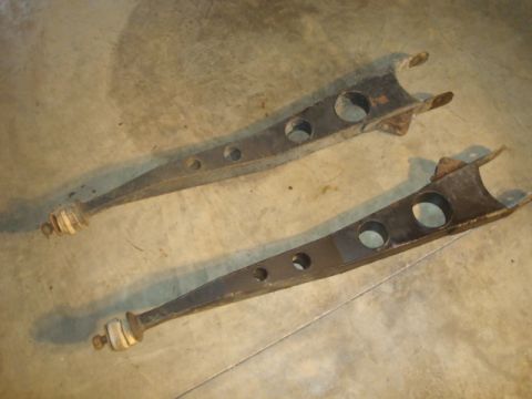 1995 Ford Bronco - A pair of used control arms are shown on a concrete surface.