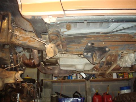 1995 Ford Bronco - The undercarriage of a vehicle is shown, revealing significant rust on the frame and suspension parts.