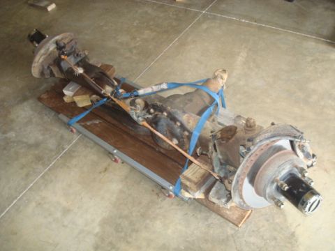 1995 Ford Bronco - Front axle assembly, likely from a truck or SUV, secured to a wooden pallet for transport.