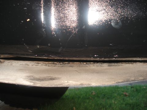 1986 Ford Bronco - A close-up view of the lower body panel and undercarriage of a vehicle.