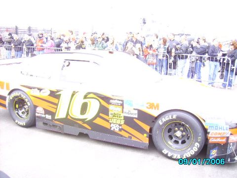 1978 Ford Bronco - A race car with the number 16 is parked in front of a crowd of spectators.