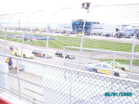 1978 Ford Bronco - Race cars are on the track with spectators in the grandstands.