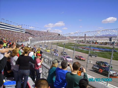 1978 Ford Bronco - A race is underway with many cars on the track and a large crowd in the stands.
