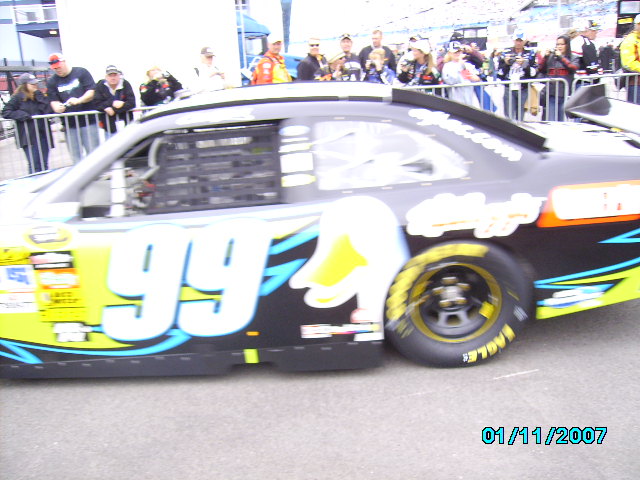 Side view of a race car with number 99 and a duck graphic