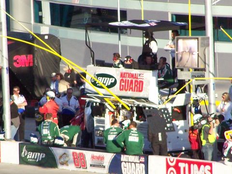 1978 Ford Bronco - A pit crew is actively working in a garage area, with prominent National Guard branding visible in the background.