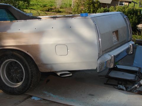 1973 Ford Ranchero - The rear of a Ford Ranchero shows primer and bodywork in progress, with a custom exhaust tip visible.