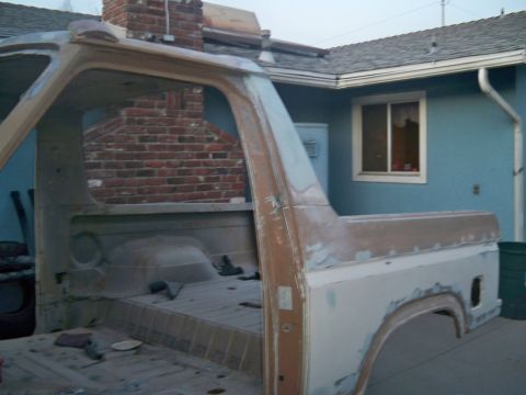 1985 Ford Bronco - The stripped-down body of a classic Ford Bronco sits outside a house, awaiting restoration.