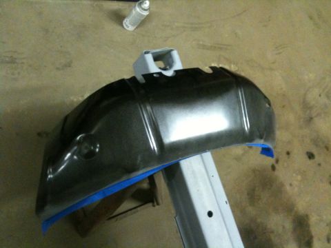1993 Ford Bronco - A vehicle fender part is shown on a stand, ready for work, with blue tape applied.