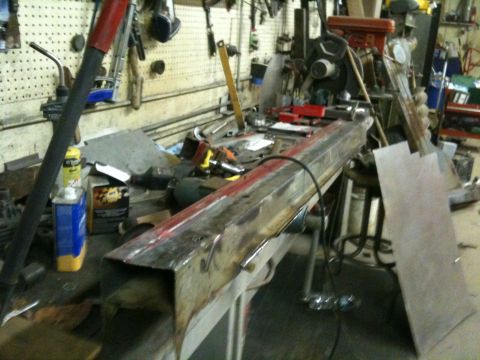 1993 Ford Bronco - Workshop scene with a workbench covered in tools and metal parts.