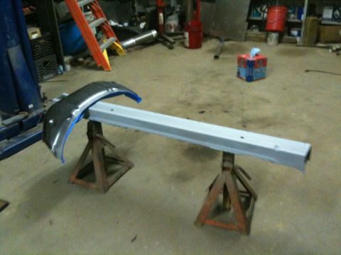 1993 Ford Bronco - A detached fender and rocker panel are supported by jack stands in a workshop environment.